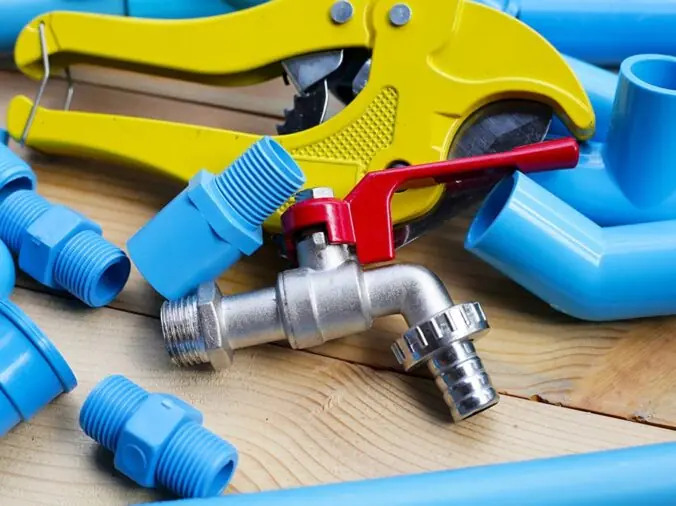 Blue PVC pipe connection pieces with a PVC pipe cutter and steel valve