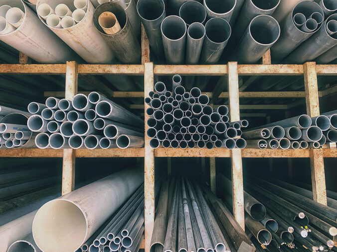 Steel and PVC pipes in shelves in a plumbing supply warehouse