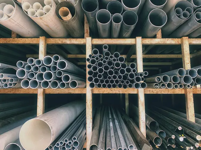 Steel and PVC pipes in shelves in a plumbing supply warehouse