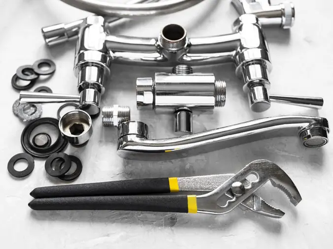 Deconstructed chrome sink faucet and plumbing plyers